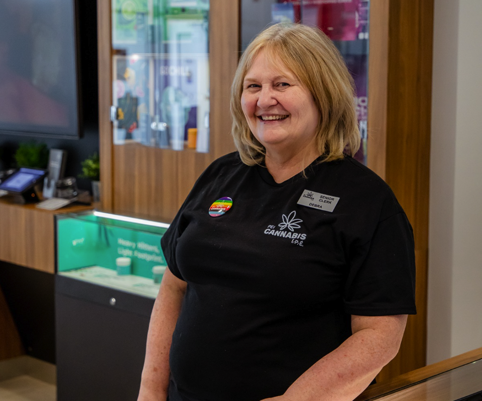 PEI-Cannabis-staff-02 Friendly PEI Cannabis staff member smiling in uniform.