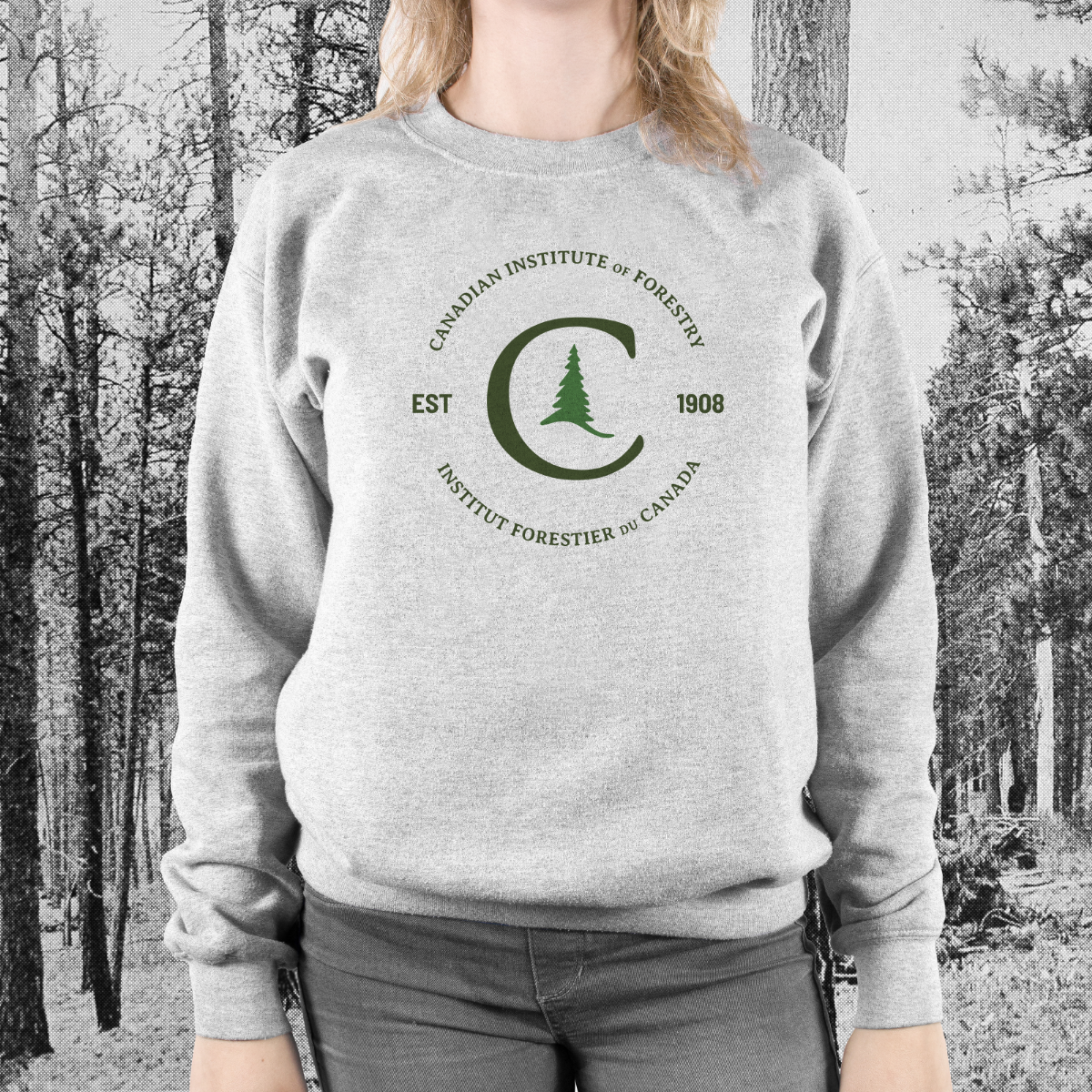 Sweatshirt-heritage Woman wearing grey sweatshirt containing green heritage logo.