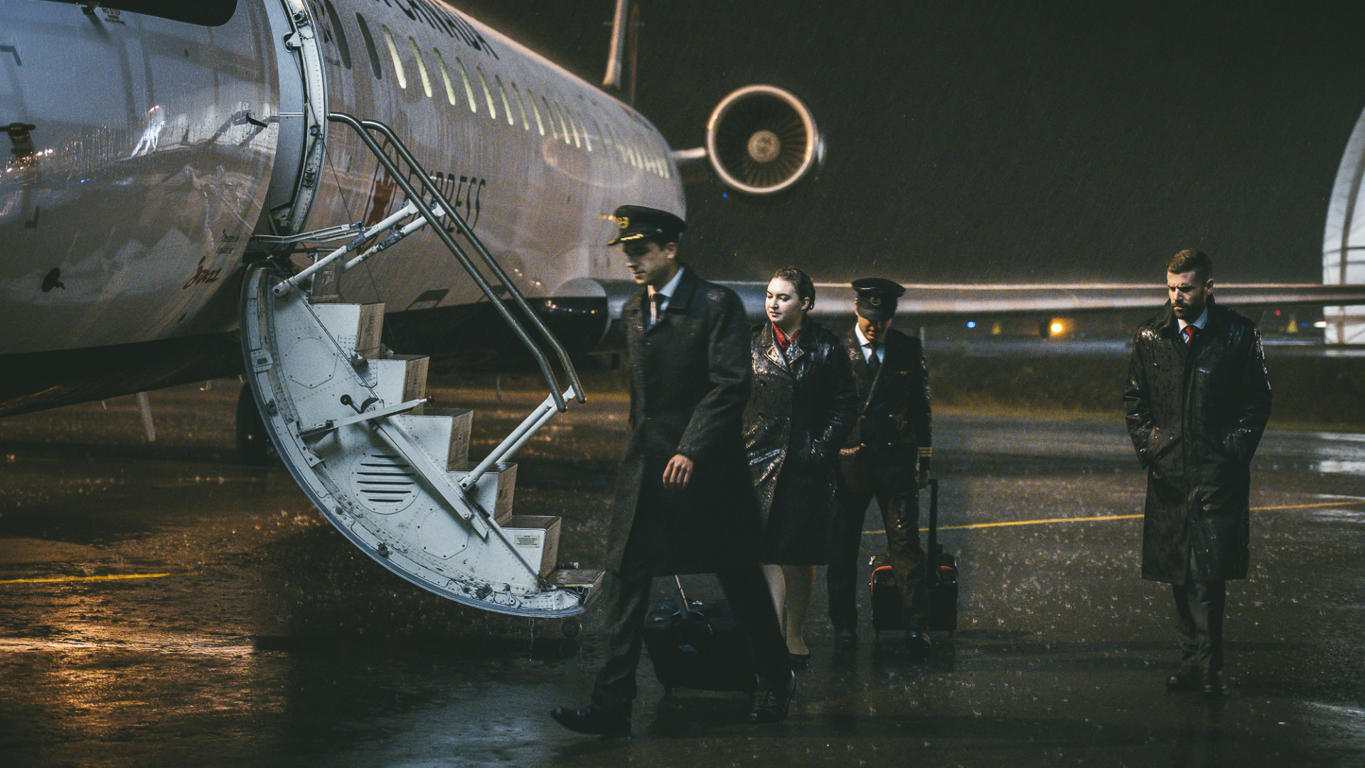 Chorus-Aviation-Frame-1 Jazz pilots and flight attendants walking towards the plane while it's dark and raining.