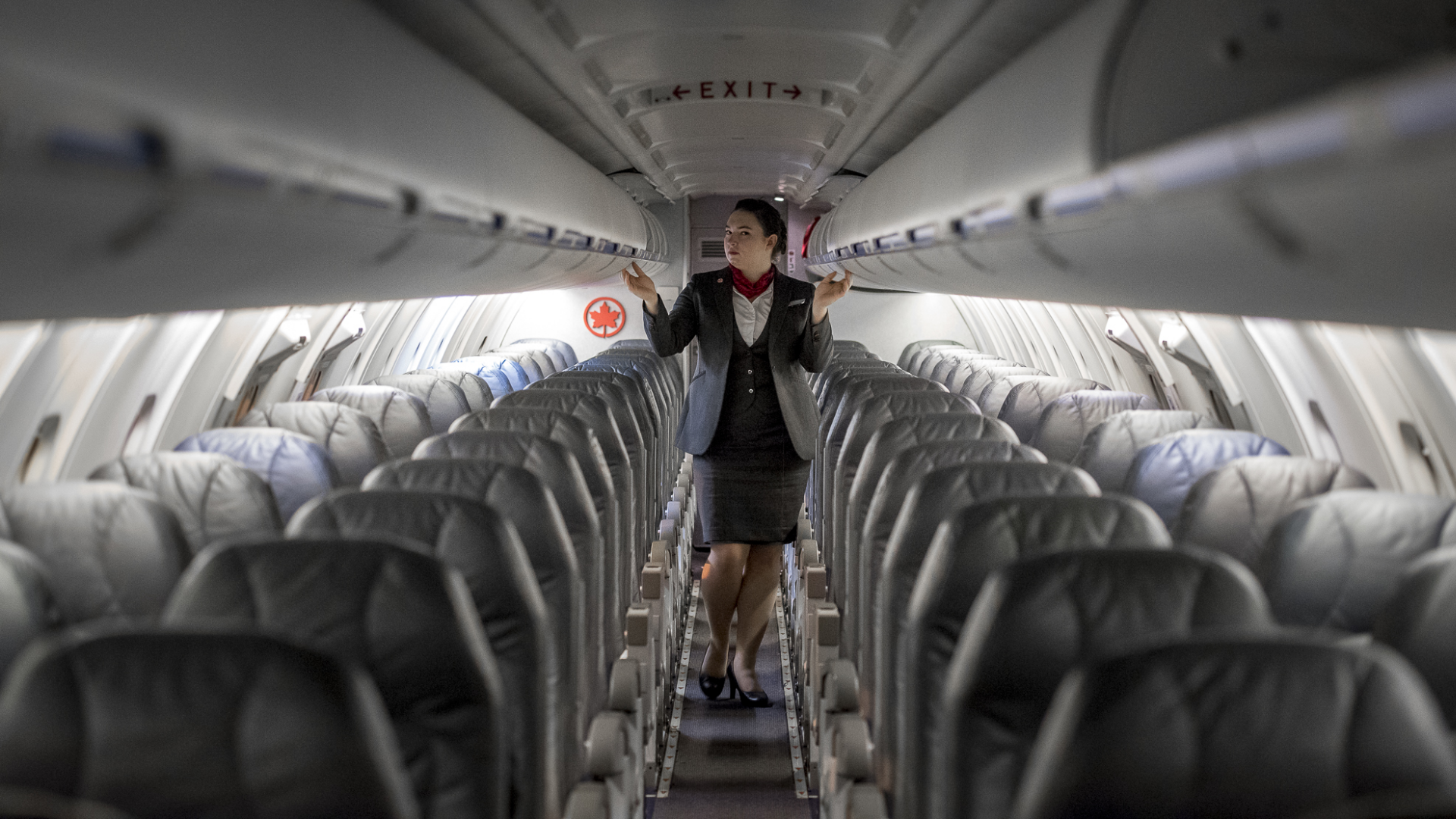 Chorus-Aviation-Frame-10 Female flight attendant walking the aisle on empty plane before flight.