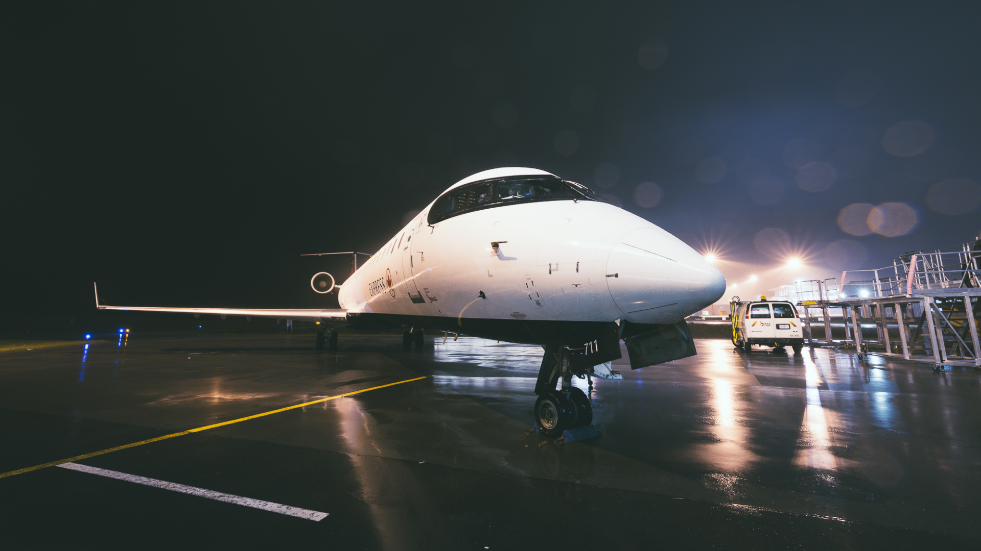 Chorus-Aviation-Frame-2 Air Canada airplane on the tarmac is the rain at night.