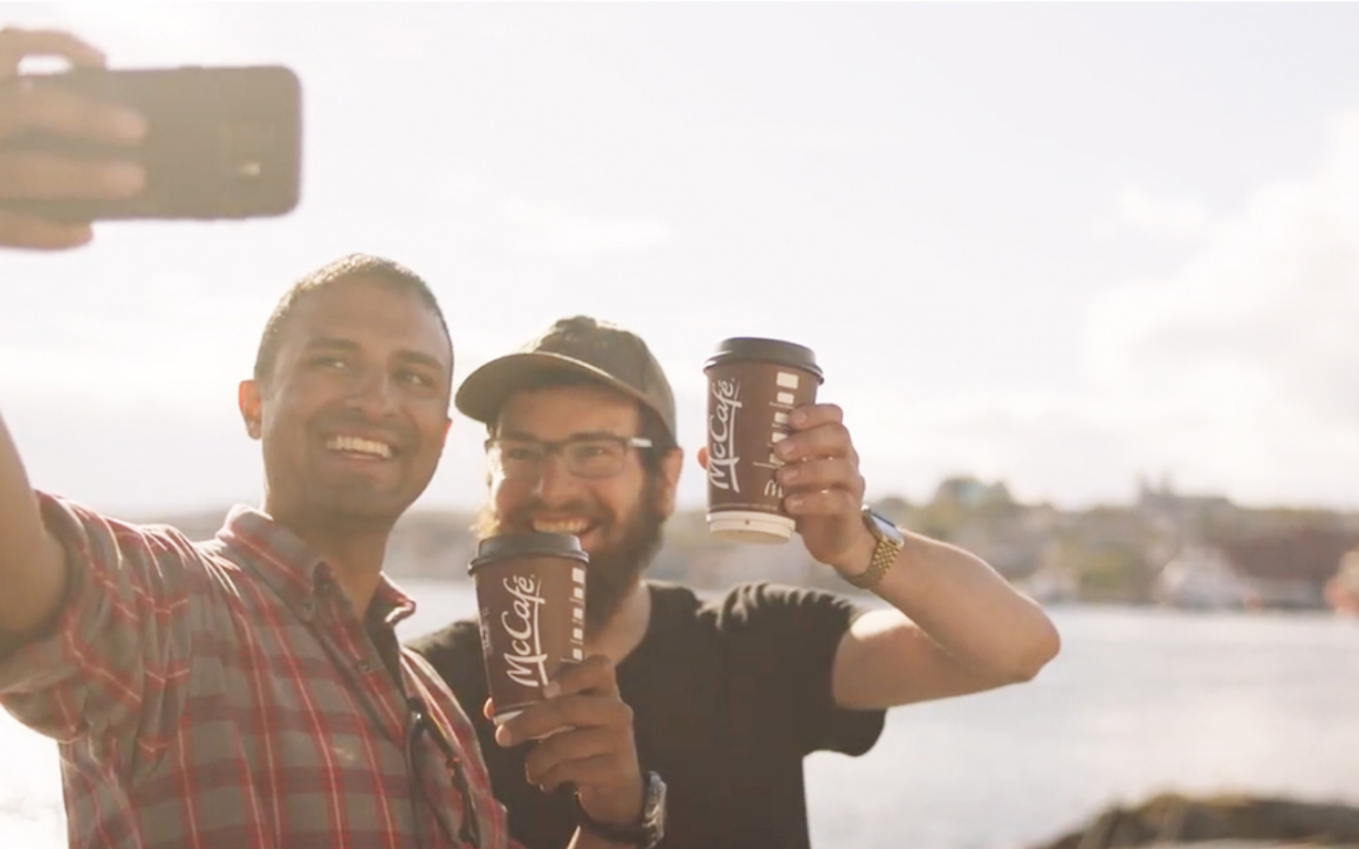 Two friends taking a selfie while enjoying a McCafe specialty premium roast coffee.