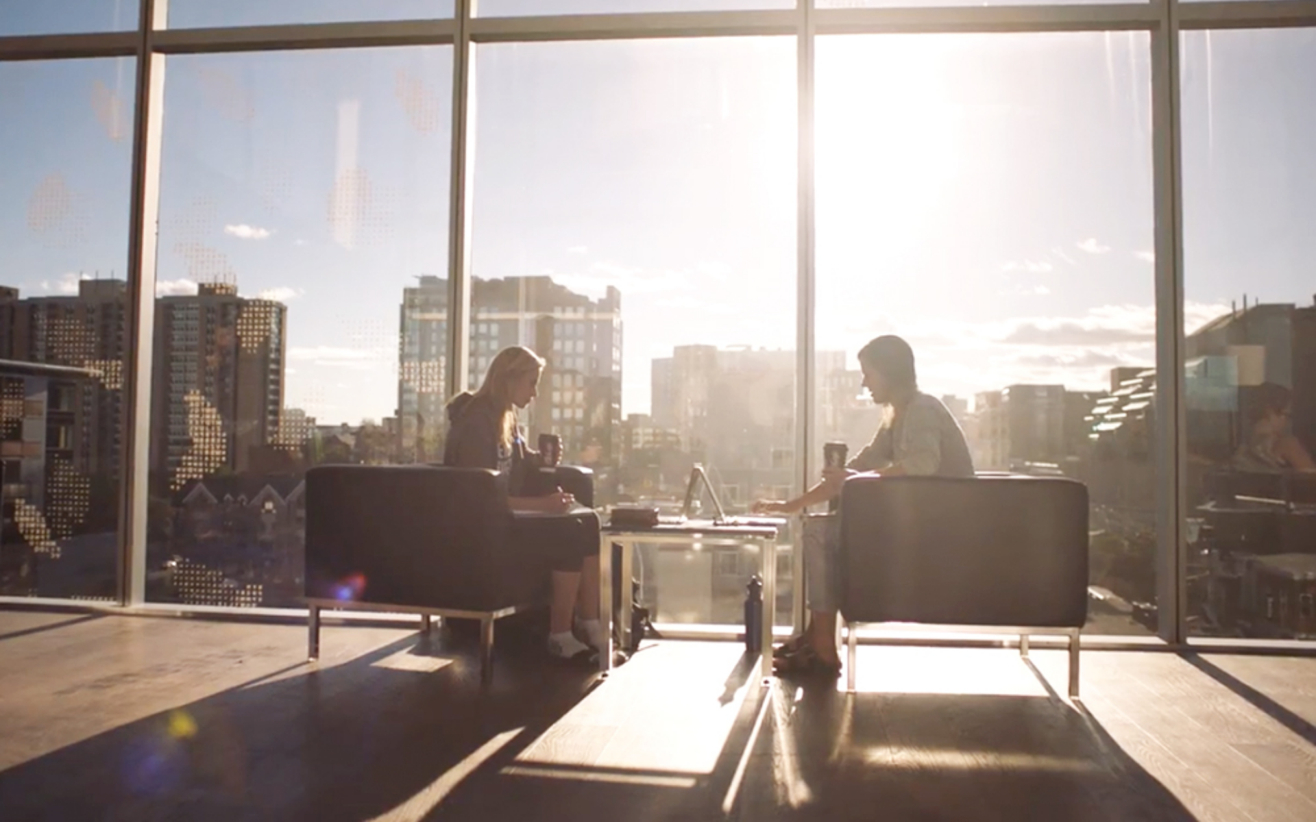 Two friends studying at Halifax Public Library while enjoying a McCafe premium roast specialty coffee.