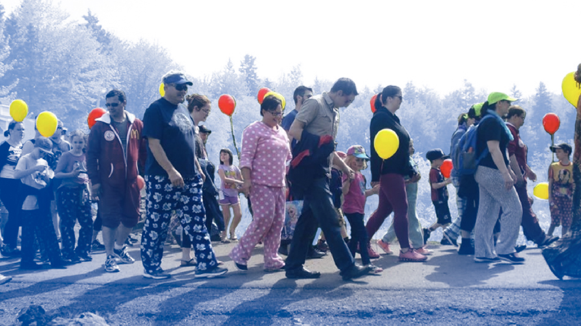 RMHCA-PJ-Walk-for-Kids-3 Parade of families holding hands, wearing pyjamas, and carrying balloons.